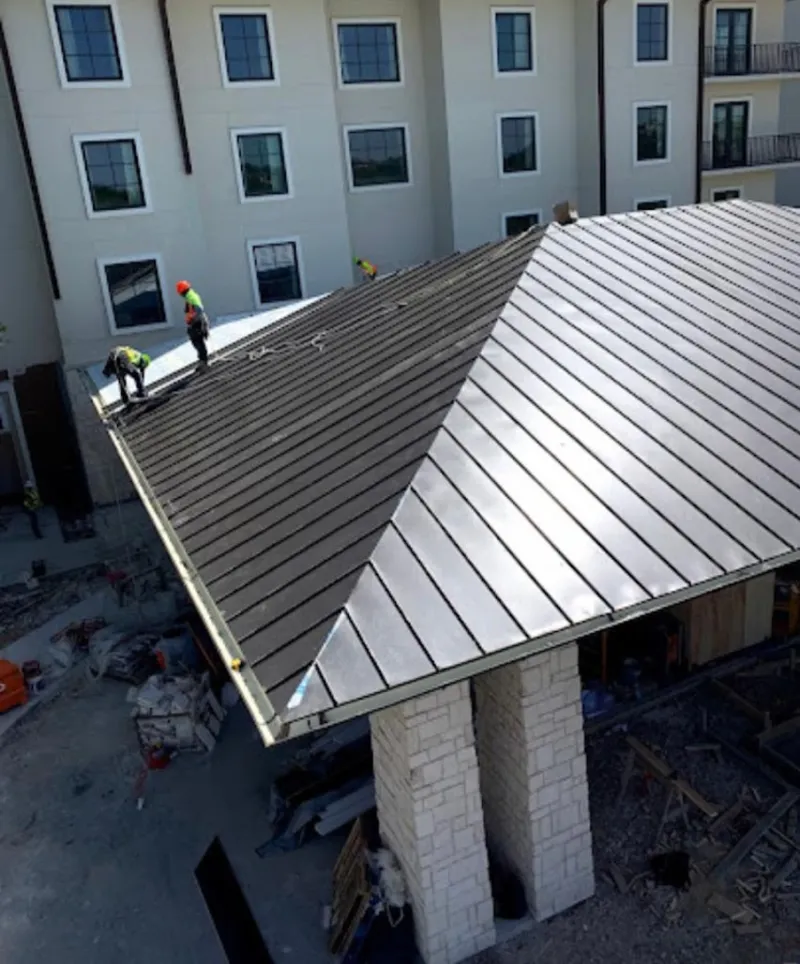 Crew installing standing seam metal roof panels on a commercial project in Satellite Beach